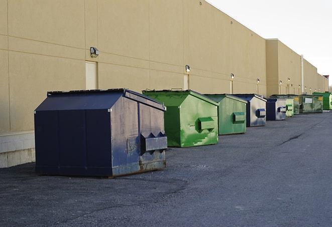 a series of colorful, utilitarian dumpsters deployed in a construction site in Boonville